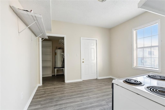 kitchen with light hardwood / wood-style floors, water heater, a textured ceiling, and white electric range oven