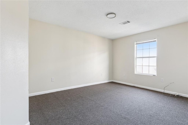 carpeted spare room featuring a textured ceiling