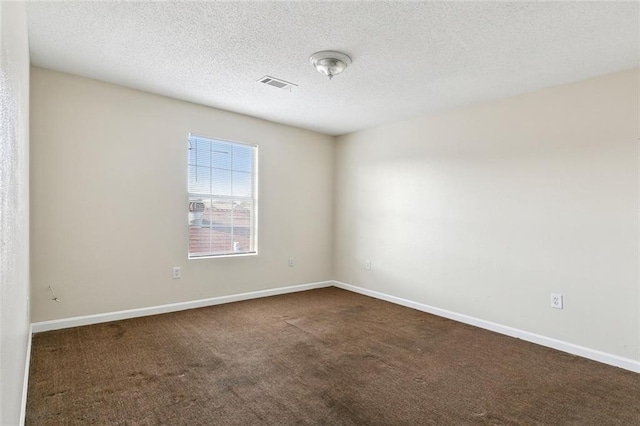 carpeted empty room featuring a textured ceiling