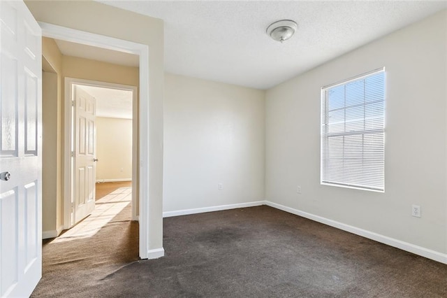 unfurnished room with dark carpet