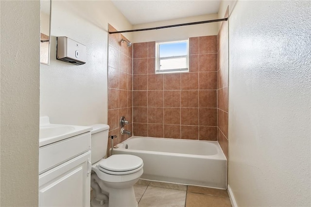 full bathroom with tile patterned flooring, vanity, tiled shower / bath, and toilet