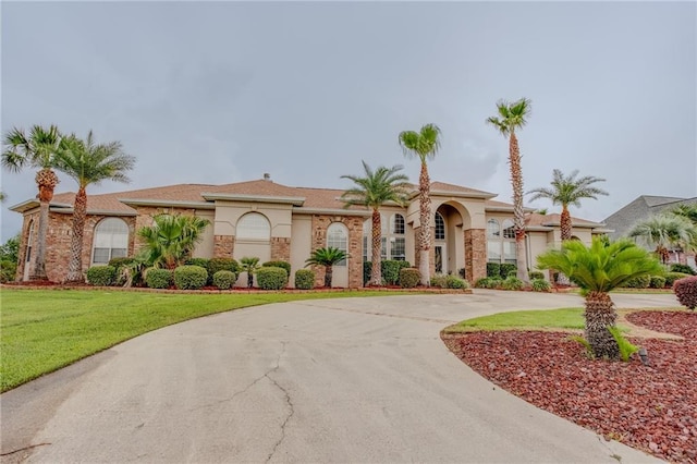 mediterranean / spanish house featuring a front yard