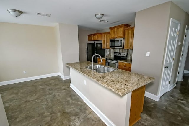 kitchen with sink, light stone countertops, kitchen peninsula, and appliances with stainless steel finishes