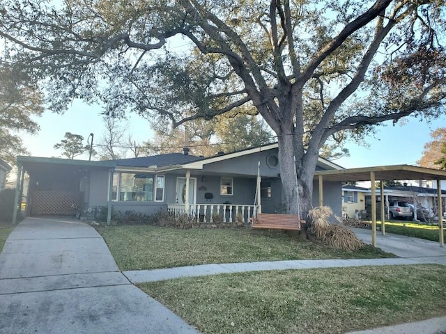 single story home featuring a carport, a porch, and a front lawn