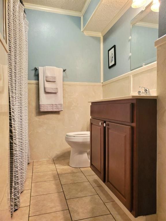 bathroom with vanity, toilet, crown molding, tile patterned floors, and a textured ceiling