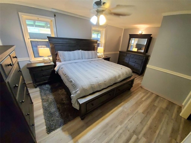 bedroom with ornamental molding, ceiling fan, and light hardwood / wood-style flooring