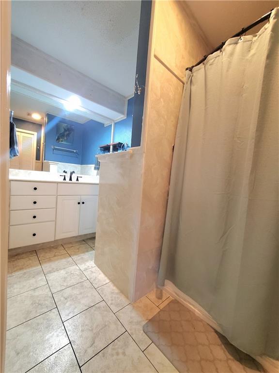 9028 Camille Ave, River Ridge, LA 70123 - bathroom with tile patterned flooring, vanity, and a shower with shower curtain