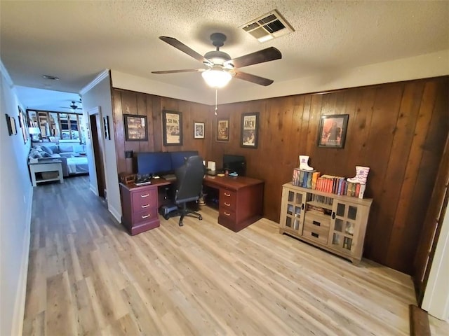 home office with ceiling fan, a textured ceiling, and light wood-type flooring