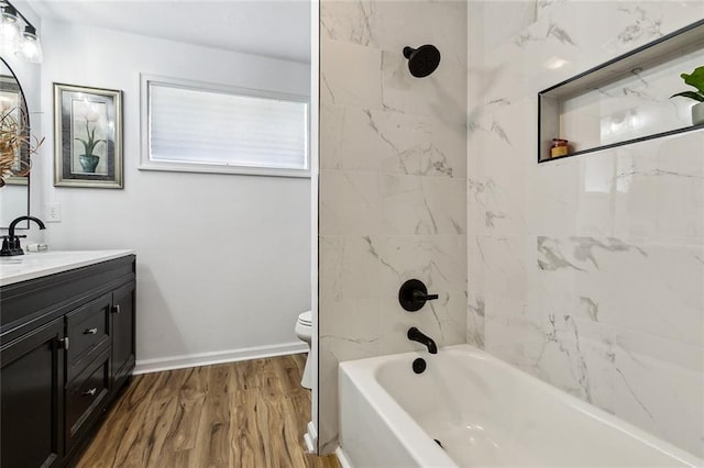 full bathroom with tiled shower / bath, vanity, toilet, and hardwood / wood-style floors