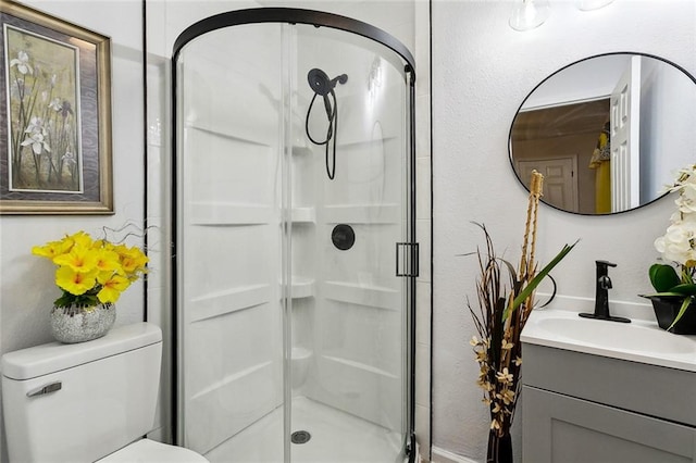 bathroom with walk in shower, vanity, and toilet