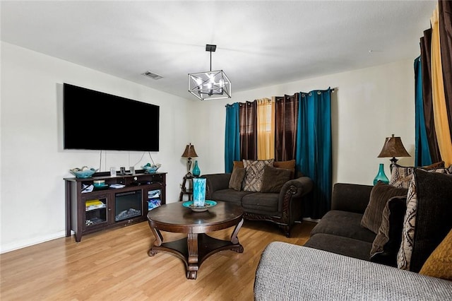 living room with hardwood / wood-style flooring and an inviting chandelier