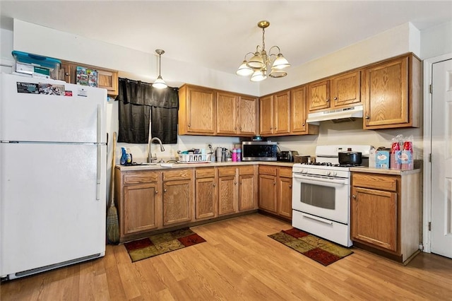 kitchen with sink, an inviting chandelier, light hardwood / wood-style flooring, pendant lighting, and white appliances