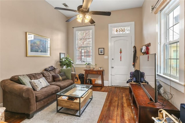 living room with ceiling fan, a healthy amount of sunlight, and dark hardwood / wood-style flooring