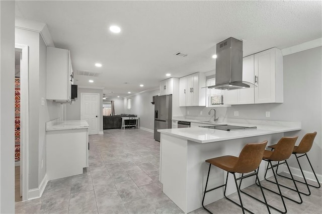 kitchen with sink, island range hood, white cabinets, and kitchen peninsula