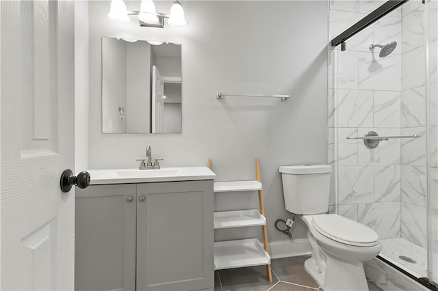 bathroom featuring vanity, toilet, and a tile shower