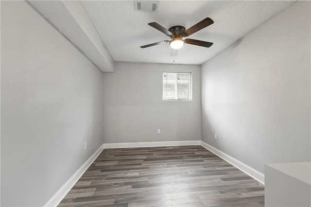 unfurnished room featuring ceiling fan, dark wood-type flooring, and a textured ceiling