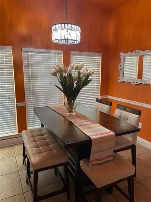 dining room with light tile patterned flooring and an inviting chandelier