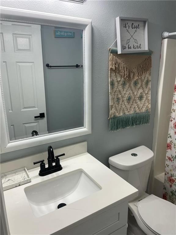 full bathroom with vanity, toilet, and shower / bathtub combination with curtain