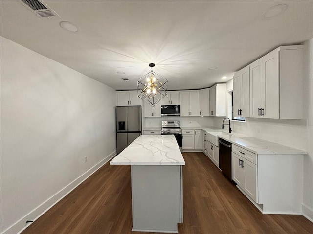 kitchen featuring appliances with stainless steel finishes, a center island, pendant lighting, and white cabinets