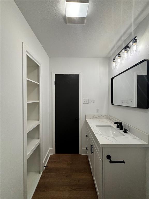 bathroom with vanity, hardwood / wood-style flooring, and a textured ceiling