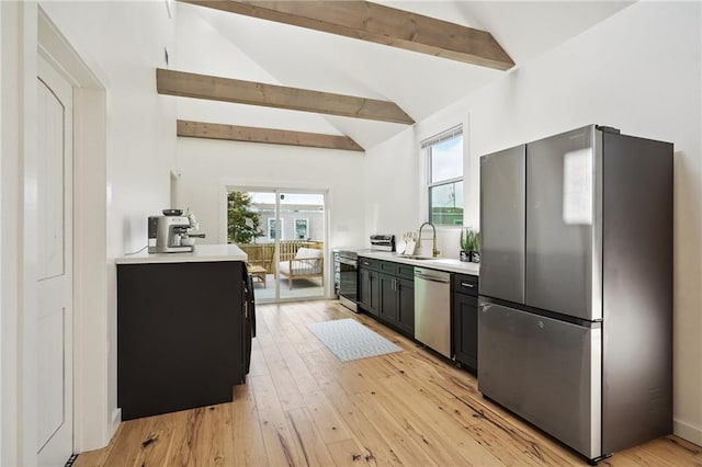 kitchen featuring light hardwood / wood-style flooring, sink, lofted ceiling with beams, and stainless steel appliances