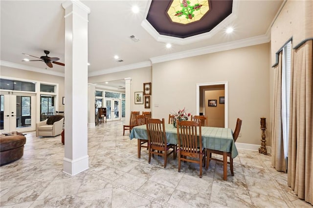 dining space featuring french doors, ornate columns, ornamental molding, a tray ceiling, and ceiling fan