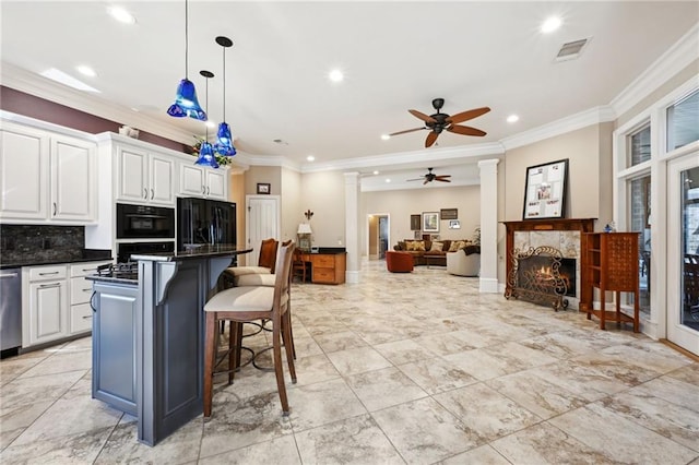 kitchen featuring a breakfast bar, white cabinetry, hanging light fixtures, black refrigerator, and a center island