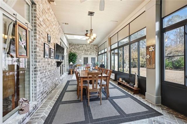 sunroom / solarium with ceiling fan with notable chandelier