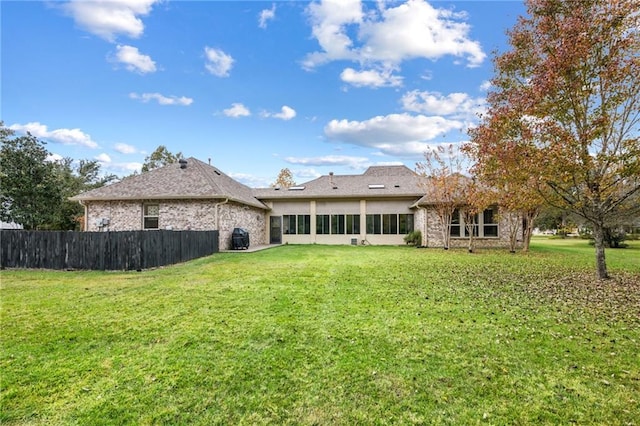 rear view of property with a lawn