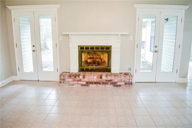 interior space with a brick fireplace, a healthy amount of sunlight, and french doors