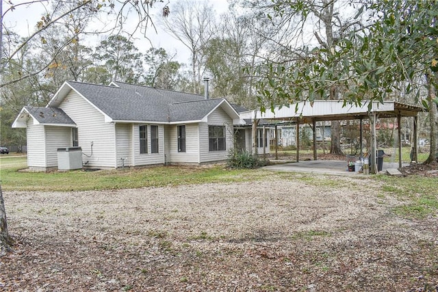 rear view of property featuring a carport and central air condition unit