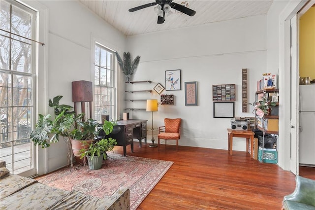 living area with hardwood / wood-style flooring, wooden ceiling, and ceiling fan