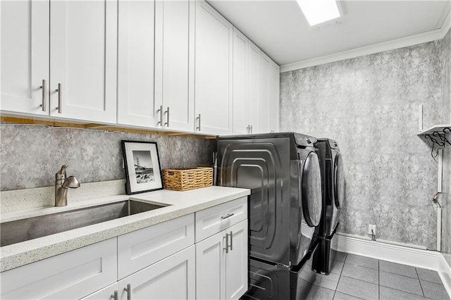 laundry area featuring sink, tile patterned flooring, cabinets, independent washer and dryer, and ornamental molding