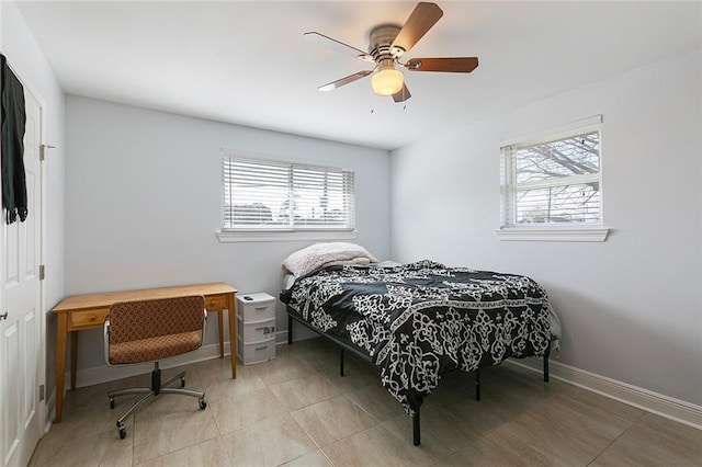 bedroom with light tile patterned flooring, ceiling fan, and multiple windows