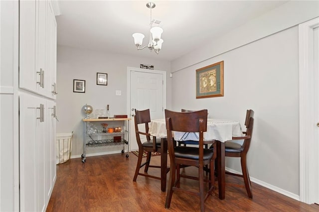 dining space featuring dark hardwood / wood-style floors and a notable chandelier