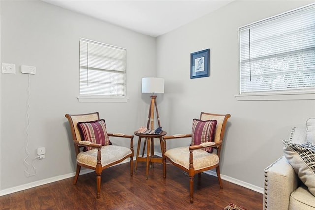 sitting room featuring dark wood-type flooring and plenty of natural light