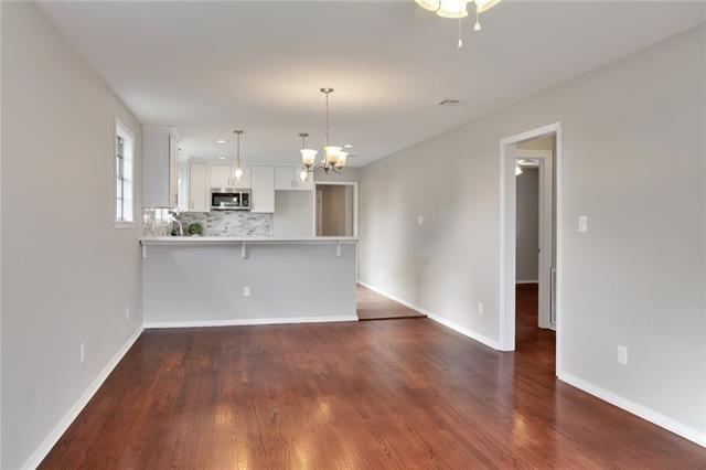 unfurnished living room with a notable chandelier and dark wood-type flooring