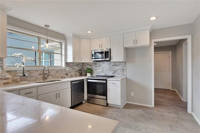 kitchen featuring stainless steel appliances, white cabinetry, and sink