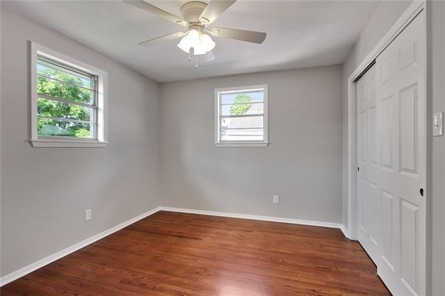 unfurnished bedroom featuring dark hardwood / wood-style floors, ceiling fan, and a closet