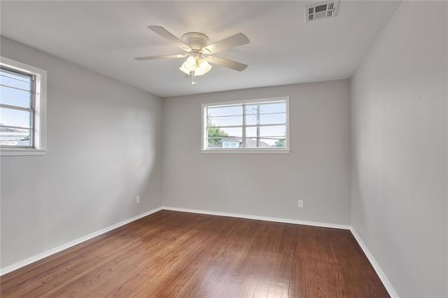 empty room featuring plenty of natural light, hardwood / wood-style floors, and ceiling fan