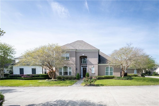 view of front of house with a front yard and stucco siding