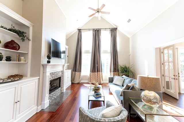 living area with high vaulted ceiling, dark wood-type flooring, visible vents, a stone fireplace, and ceiling fan