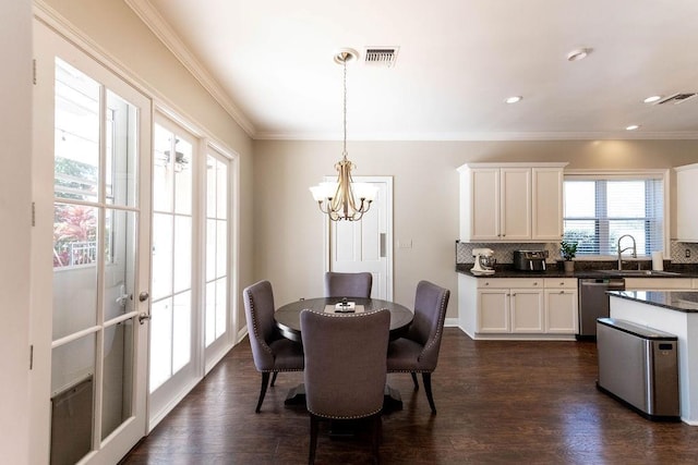 dining space with dark wood-style floors, visible vents, ornamental molding, and an inviting chandelier