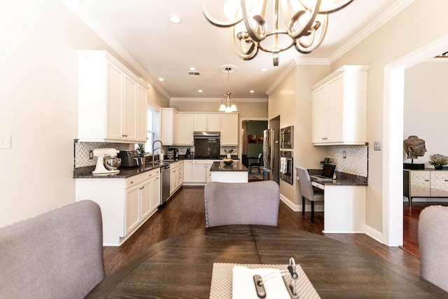 kitchen with dark wood-style floors, a sink, an inviting chandelier, and appliances with stainless steel finishes