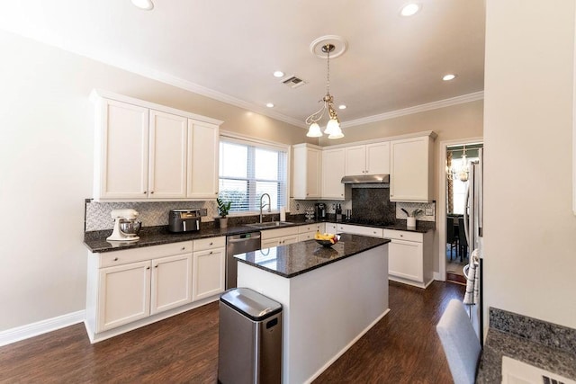 kitchen with sink, decorative light fixtures, white cabinets, and a kitchen island