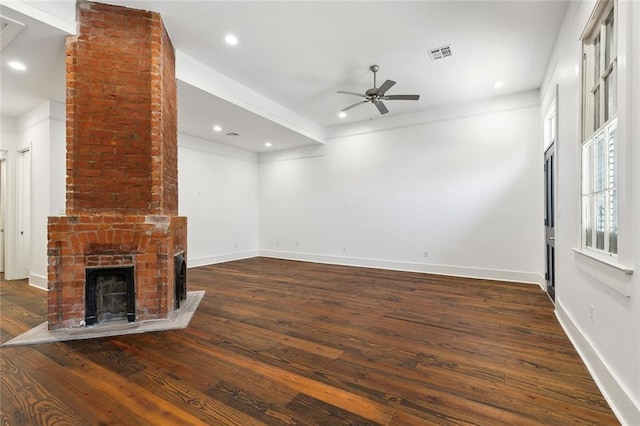 unfurnished living room featuring dark wood-type flooring, ceiling fan, and a fireplace