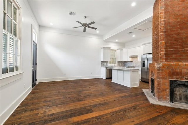 kitchen featuring dark wood-type flooring, a center island, tasteful backsplash, white cabinets, and stainless steel fridge with ice dispenser