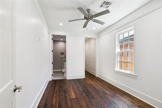 unfurnished bedroom with dark hardwood / wood-style floors, ceiling fan, and ensuite bathroom