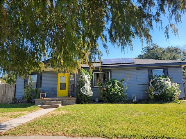 ranch-style home with a front lawn and solar panels