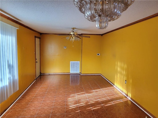 empty room featuring ceiling fan, ornamental molding, and a textured ceiling